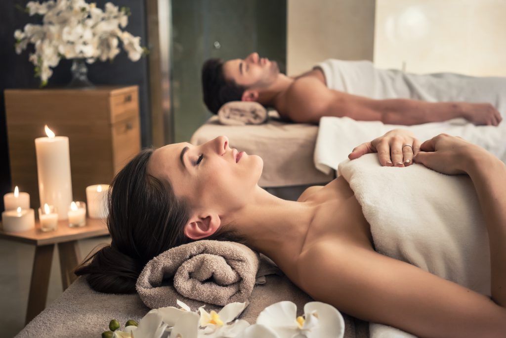 Young man and woman lying down on massage beds on a top luxury cruise spa and wellness center